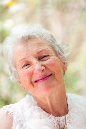 Old lady looking at you with love. She has grey hair and complimenting nice clothing.の写真素材