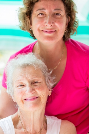 Old mother and her daughter posing with satisfied look.の写真素材