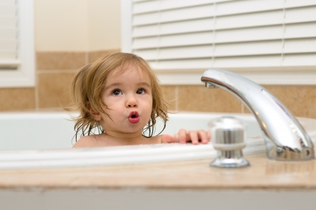 Toddler girl giving expression that needs hot water to take her bathの写真素材