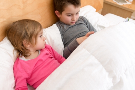 Siblings are reading a book for togetherness.の写真素材
