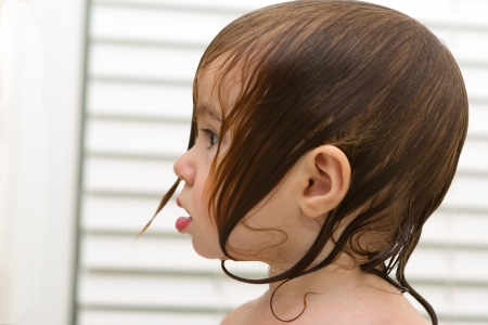 Wet haired toddlers side look, she have surprized, shocked moment, perhaps she saw the soap coming の写真素材