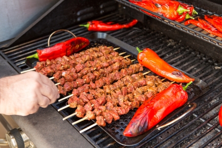 Ten pieces of barbecue and 4 pieces of chili being grilled.の写真素材