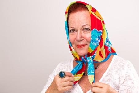 Old lady giving a happy satisfied look in her colorful headscarf