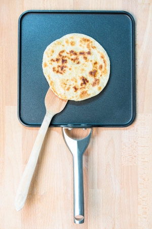 Traditional parathe served in contemporary square pan with wooden utensilの写真素材