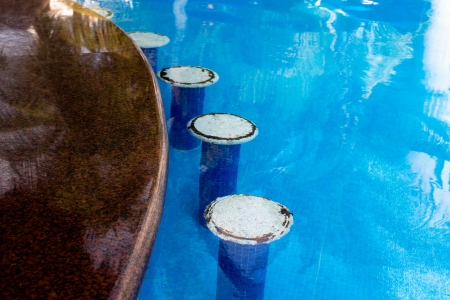 White bar seats in the swimming pool, rusty irons coming out from the seats giving authentic look, horizontalの写真素材