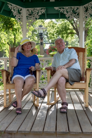 Senior couple resting in the gazebo protecting themselves from the sunの写真素材