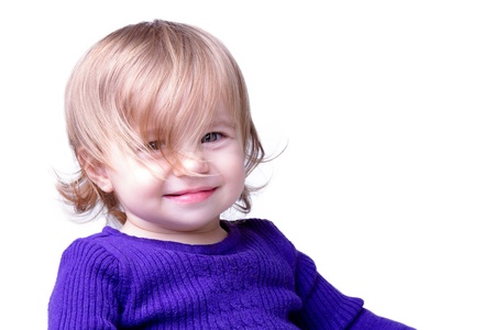 Little girl is smiling through her long never cut messy hair. Isolated on white background.の写真素材