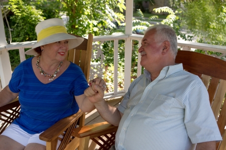 Portrait of mature couple sitting on the terrace while talkingの写真素材