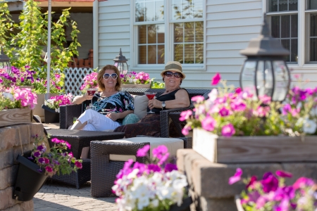 Senior ladies having their martinis with cherries in a flower full brick patio.の写真素材