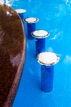 White bar seats in the swimming pool, rusty irons coming out from the seats giving authentic look, verticalの写真素材