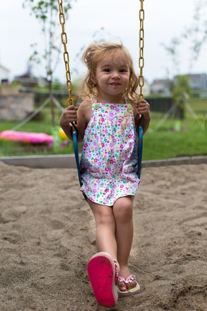 Little girl posing on the swing in a very natural wayの写真素材