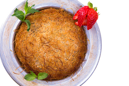 Turkish dessert kunefe isolated on a white background with mints and sliced strawberryの写真素材