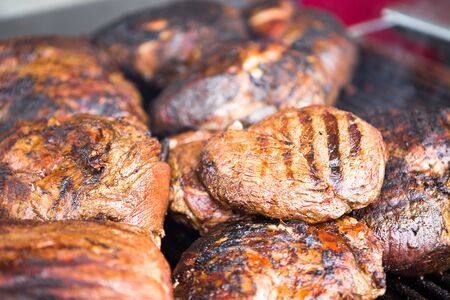 Several grilled boneless rib-eye steaks on a barbecue restingの写真素材