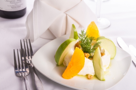 Strained yogurt labneh citrus salad with peeled oranges and green apples garnished with dill and walnuts served with oilの写真素材