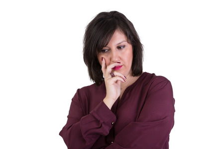 Middle Aged Businesswoman in shirt looking down thoughtfully with her hand on her faceの写真素材