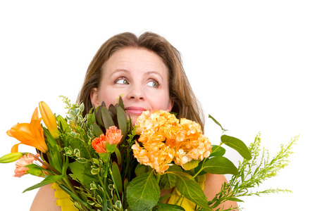 Happy woman looking up behind the flower  bouquet expressing her positive feelings genuinelyの写真素材