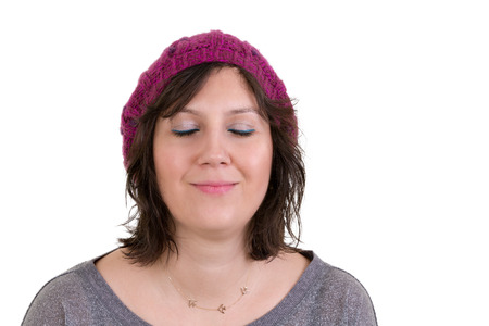 Woman wearing a purple knitted cap with an expression of pure bliss smiling in ecstasy with her eyes closed isolated on whiteの写真素材