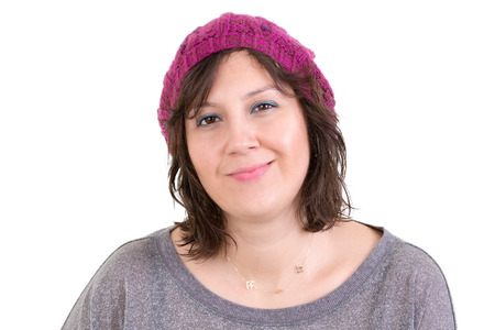 Happy attractive young woman with a charming smile wearing a purple knitted beanie, head and shoulders on whiteの写真素材