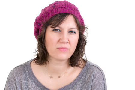 Woman making a judgemental assessment looking at the camera with a pensive analytical expression, isolated on whiteの写真素材