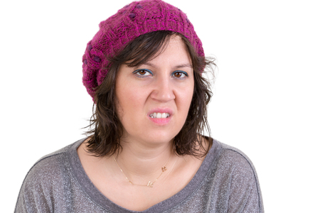 Nasty vindictive woman with a cold mean stare looking at the camera with a sneer, head and shoulders isolated on whiteの写真素材