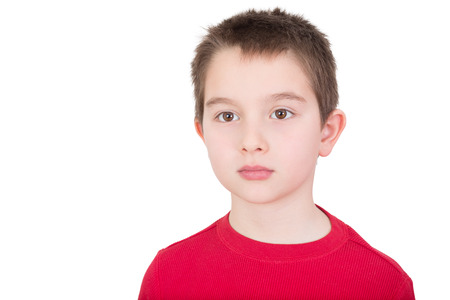 Sad wistful young boy with a solemn introvert expression staring off into the distance isolated on white with copyspaceの写真素材