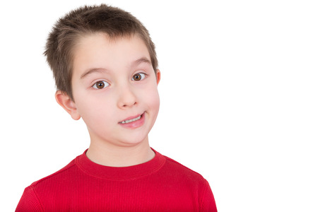 Skeptical young boy reacting in disbelief smiling ruefully and raising an eyebrow, isolated on whiteの写真素材