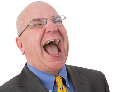 Caucasian middle-aged bald businessman wearing glasses and formal business suit while laughing out loudの写真素材
