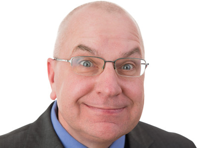 Zealous businessman with a fanatical expression grinning at the camera with his eyes opened wide in expectation that the viewer will agree with him, head and shoulders portrait on whiteの写真素材