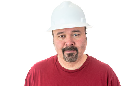 Workman or technician with a goatee beard wearing a white hardhat standing looking directly at the camera, isolated on whiteの写真素材
