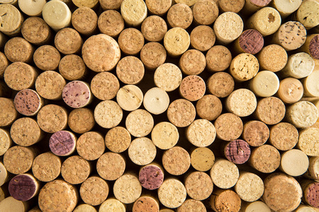 texture of neatly arranged corks from wine and champagne bottles packed tightly together with their tops facing up to the camera forming a circular patternの写真素材
