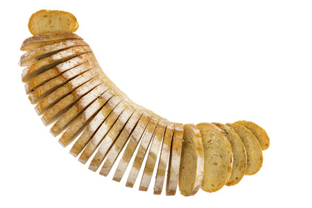 Fresh loaf of sliced rosemary and potato bread arranged in a crescent shape with the slices splayed,...