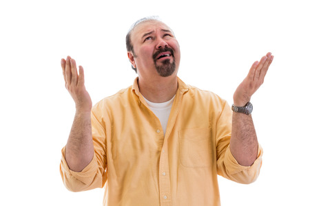 Confused perplexed man asking for clarification from Heaven raising his hand with a bemused expression, part of a series on body language, isolated on whiteの写真素材