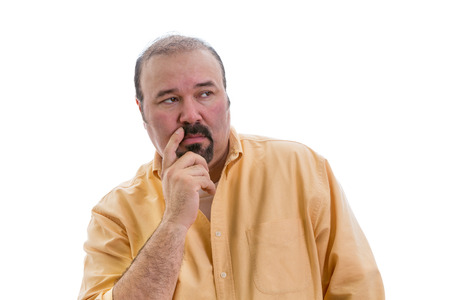 Observant speculative middle-aged man with a goatee standing thinking and looking to the right side of the frame with a serious expression, part of a series on body language, isolated on whiteの写真素材