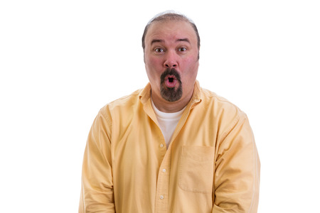 Middle-aged man reacting in awe and amazement standing with wide open eyes and mouth and an excited expression, part of a series on body language, isolated on whiteの写真素材