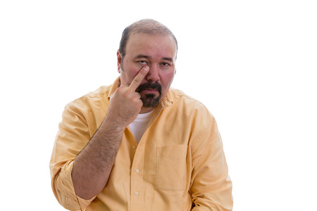 Man gesturing touching his nose with a finger showing that he knows a secret and the viewer would be wise to pay special heed or it is also sometimes used in derision, isolated on whiteの写真素材