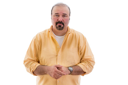 Compassionate sincere middle-aged man standing with clasped hands looking at the camera with an expression of empathy, isolated on whiteの写真素材