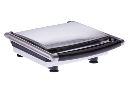 Modern electric panini sandwich maker with the lid closed viewed at an angle isolated on whiteの写真素材