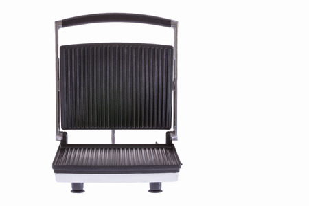 Low angle frontal view of an open electrical panini press or grill with cast iron teflon-coated plates isolated on whiteの写真素材