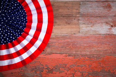 Patriotic Independence Day Badge to celebrate the Fourth of July in the colors of the American flag with stars and stripes on a rustic wooden table with copyspaceの写真素材