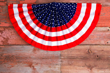 4th of July patriotic rosette in the stars and stripes of the USA National flag to celebrate Independence Day lying on rustic wooden boards with copyspace, view from aboveの写真素材