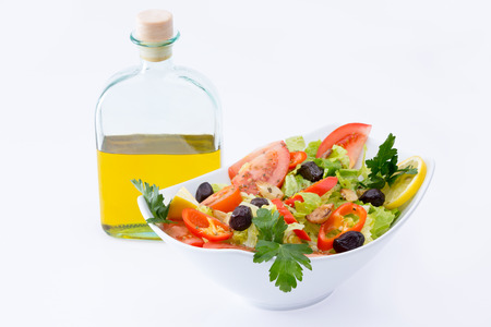 Fresh Mediterranean salad with olives, tomatoes, parsley, lemon, peppers, lettuce with extra virgin olive oil in the backgroundの写真素材