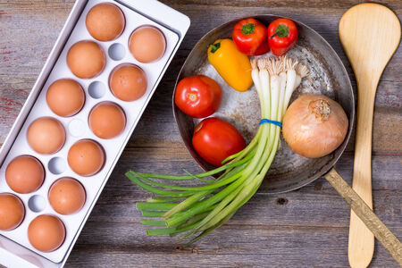 Preparing a healthy vegetarian omelet with an overhead view of eggs in a tray の写真素材
