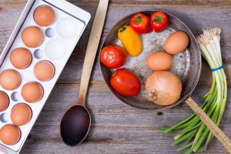 Cooking a healthy vegetarian omelet with a view from above of eggs in a trayの写真素材