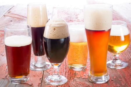 Variety of different beers, of different colors and alcoholic strengths in different shaped glasses suited to different personalitiesの写真素材