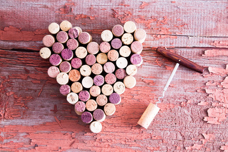 Close up Corks in Heart Shape and Wine Bottle Opener on Top of a Rustic Wooden Table for Love Concept. Captured in High Angle View.の写真素材