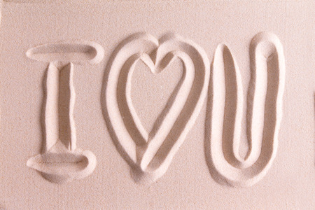 I Love You drawn in golden beach sand with a symbolic heart for romance and love for your sweetheart or Valentine in a simple elegant card design or backgroundの写真素材