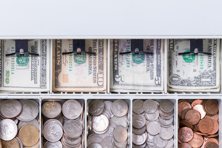 Close up on American currency in cash drawer consisting of pennies, dimes, nickels, quarters and various paper billsの写真素材