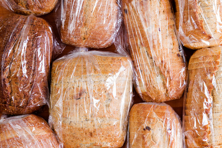 Assortment of different healthy white, wholegrain and wholewheat sliced loaves of fresh bread sealed...