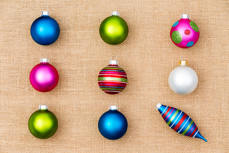 Festive Christmas still life with colorful Xmas tree ornaments arranged in neat rows of baubles with a single spindle conceptual of individualism and diversityの写真素材