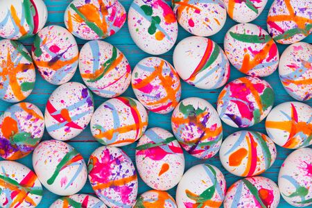 High-angle close-up view of white eggs painted in vivid colors as festive full frame Easter backgroundの写真素材